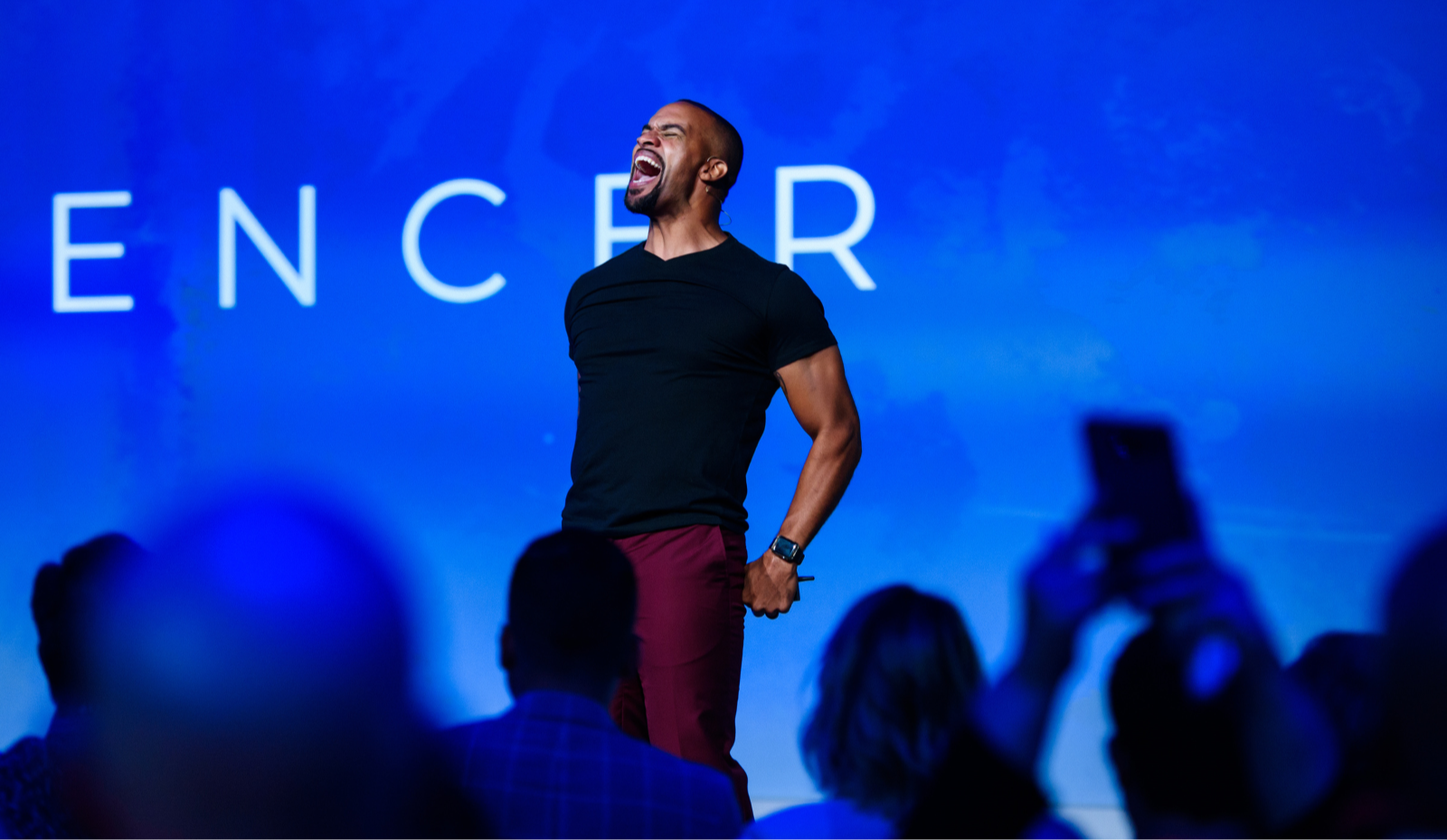 Anthony Trucks speaking on stage in front of an audience